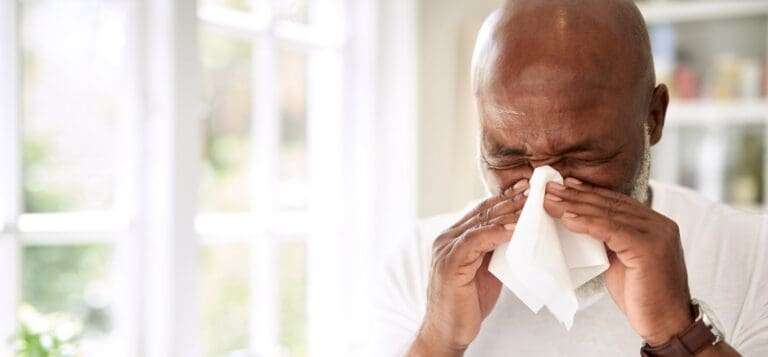 A man suffers from allergies in his home